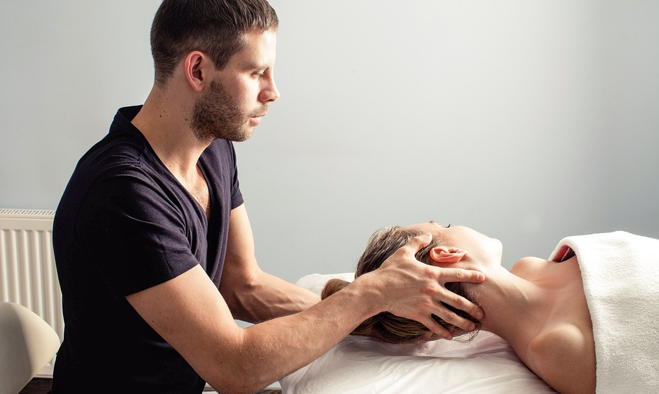 Professional massage therapist treating patient in clinic